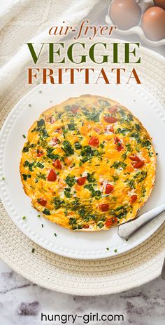 an egg frittata on a plate with eggs in the background and text overlay that reads air - fryer veggie frittata