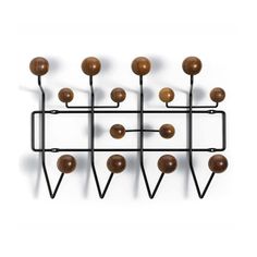 a metal rack with many balls on it and some black poles attached to the wall