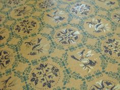 an old fashioned table cloth with blue and white designs on yellow background, closeup