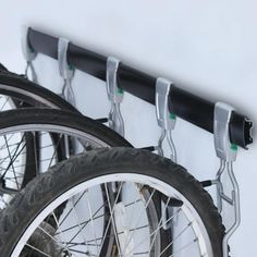 there are two bikes parked next to each other on the wall with bike racks in front of them