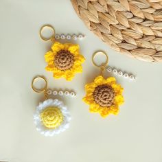 three crocheted flower keychains sitting on top of a table