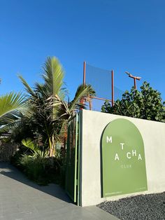 the entrance to mt macha club with palm trees and blue sky in the background