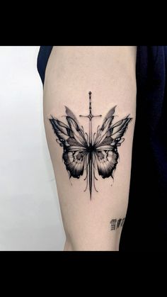 a cross and butterfly tattoo on the right side of the thigh, which is black and white