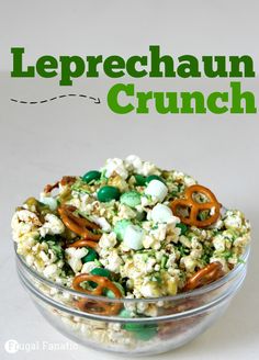 a glass bowl filled with cereal and pretzels on top of a white table