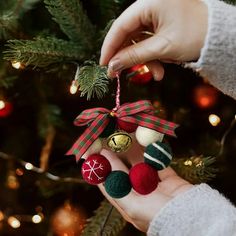 a person holding a christmas ornament in their hand