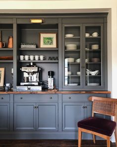 a kitchen with gray cupboards and wooden flooring next to a dining room table