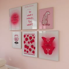 four framed pictures hang on the wall above a couch in a pink room with white furniture