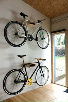 two bikes mounted to the wall in a room