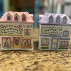 two small ceramic houses sitting on top of a counter