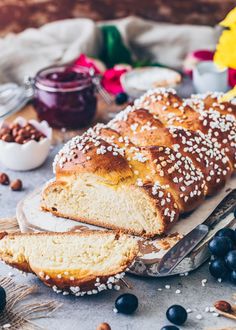 a loaf of bread sitting on top of a table next to blueberries and nuts