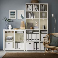 a living room filled with furniture and bookshelves next to a wall covered in pictures