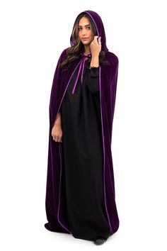 a woman in a purple robe is talking on her cell phone while standing against a white background