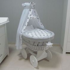 a white wicker baby's carriage in a room