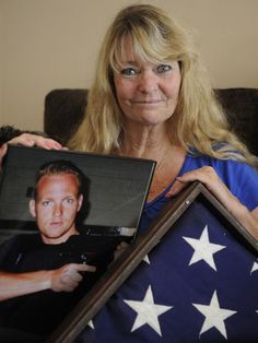 a woman holding an american flag and a framed photo