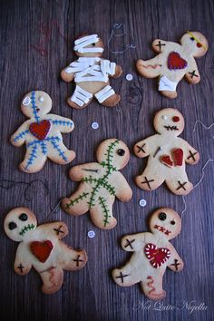 several decorated cookies are arranged on a wooden table with white string and red heart decorations