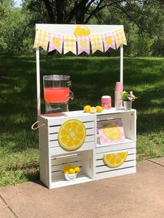 an outdoor lemonade stand is set up in the grass