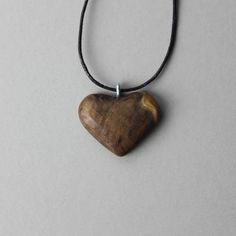 "Your wooden heart pendant has been meticulously hand carved and designed out of precious burl wood. Celebrate 5 loving years of love and joy with this one of a kind wooden hearth shaped necklace. Wood is the traditional 5th anniversary gift. D E T A I L S * This pendant is ready to ship * Handcarved from burl wood * Choose your necklace style and length * Shipped in a beautiful box for easy gift giving * Gift message available upon request (leave in notes) P E N D A N T ∙ S I Z E * 1.5\" / 38 m Heart-shaped Brown Necklace For Gift, Brown Heart-shaped Necklace For Gift, Handmade Mahogany Necklace For Gift, Brown Heart Charm Necklace As A Gift, Brown Necklace With Heart Charm For Gift, Brown Heart Charm Necklace For Gift, Brown Heart Charm Necklace As Gift, Engraved Natural Wood Necklace As Gift, Engraved Natural Wood Necklace For Gift