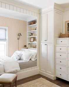 a white bed sitting in a bedroom next to a dresser with drawers on top of it