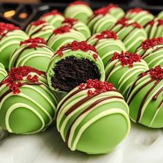 there are many green chocolates with red sprinkles on them