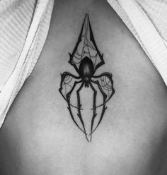 a black and white photo of a spider tattoo on the back of a woman's stomach