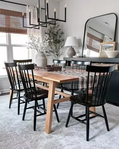 a dining room table with four chairs and a large mirror