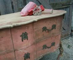 an old pink dresser with glass knobs on it