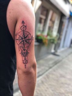 a man's arm with a tattoo on it that has a compass in the middle