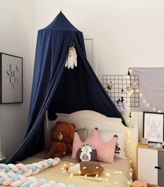 a child's bed with stuffed animals on it and a blue canopy over the bed