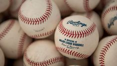 many baseballs are stacked together in a pile