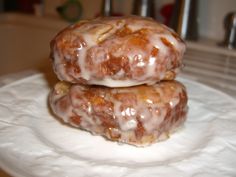 two glazed donuts sitting on top of a white paper towel