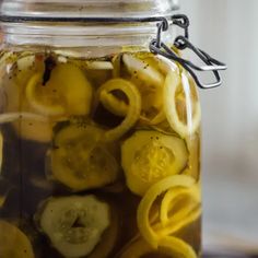 pickles and lemons are in a jar full of water