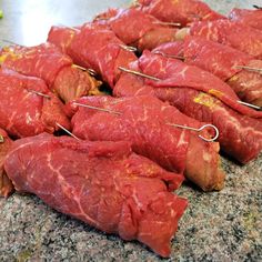 several pieces of meat on skewers sitting on top of a granite countertop