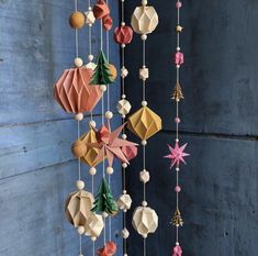 an origami mobile hanging on a wall with christmas decorations and ornaments attached to it