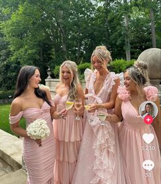 the bridesmaids are all dressed in pink dresses and holding champagne glasses for each other