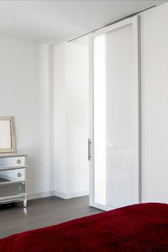 a bedroom with white walls and red carpet