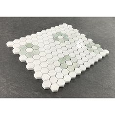 white hexagonal tile with green dots on it