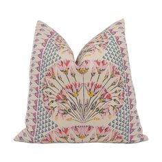 a pink and blue pillow with an intricate floral design on the front, sitting on a white background