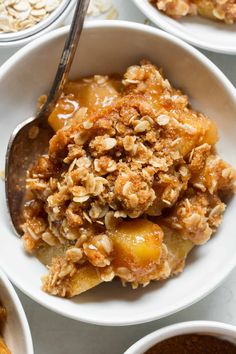 a bowl filled with oatmeal and fruit on top of a white table