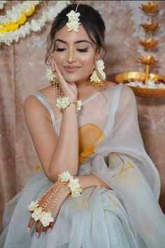 a woman in a white and yellow dress with flowers on her head is posing for the camera