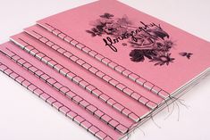 a stack of pink notebooks sitting on top of each other