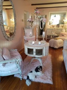 a living room filled with furniture and a dog laying on the floor next to it