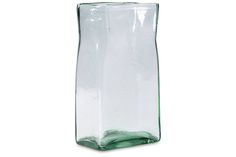 a green glass vase sitting on top of a white table