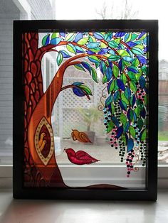 a stained glass window with a tree and birds