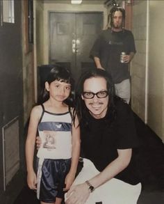 an old photo of a woman and child in the hallway with two men behind her