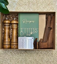 a box with some items in it on top of a carpeted floor next to a potted plant