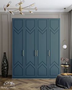 a bedroom with blue cupboards and a gold lamp on the wall next to it