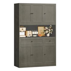 a gray cabinet with flowers and other items on it's shelf, against a white background