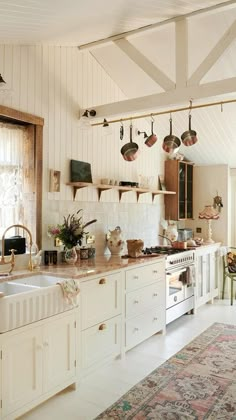 a kitchen filled with lots of white cabinets and counter top space next to a window