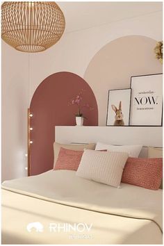 an image of a bedroom setting with pink and white decor on the walls, bedding and pillows