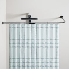 a blue and white plaid shower curtain hanging on a metal rod